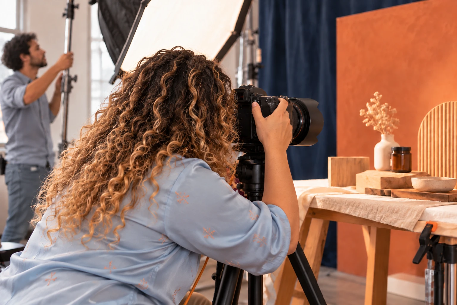 Camera operator framing a product shoot on set